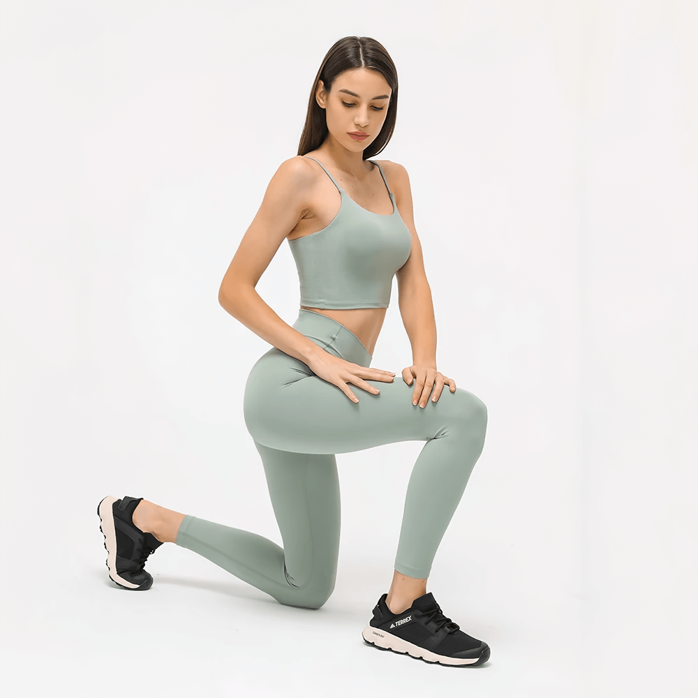 Woman wearing Quick Dry Solid Color Sleeveless Yoga Set SF2144 in green, demonstrating dynamic pose for optimal performance and style.